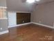 Empty bedroom featuring wood flooring, wood accent wall, a window, and neutral paint at 7218 Alexander Farm Rd, Monroe, NC 28110