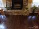 Stone fireplace with hardwood floors and stone hearth showcasing a cozy and inviting focal point at 7218 Alexander Farm Rd, Monroe, NC 28110