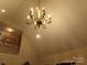 Elegant chandelier hangs from vaulted ceiling, adding sophistication to living space with staircase at 7218 Alexander Farm Rd, Monroe, NC 28110