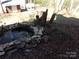 A rock-lined pond with a fountain and trees in the background at 7218 Alexander Farm Rd, Monroe, NC 28110