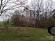 Front yard with lush green grass and mature trees, showcasing a tranquil and well-maintained outdoor space at 7218 Alexander Farm Rd, Monroe, NC 28110