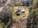 Aerial view of home with large yard, wooded border, and detached carport/storage at 724 Rocky River W Rd, Charlotte, NC 28213