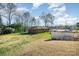 A brick ranch with a large backyard, storage building, and wooded area at 724 Rocky River W Rd, Charlotte, NC 28213