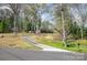 Brick home with a long driveway amid a scenic landscape of trees at 724 Rocky River W Rd, Charlotte, NC 28213