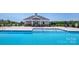 Zero entry community swimming pool with easy access and clubhouse with tables, shaded by a cloudless, bright blue sky at 7869 Iron Rd, Sherrills Ford, NC 28673