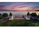 Manicured landscaping and lake views highlight this backyard, creating a serene setting with tasteful decor and plantings at 8228 Bay Pointe Dr, Denver, NC 28037