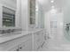 Bright bathroom with dual sinks, marble countertop, white cabinets, and shower at 8228 Bay Pointe Dr, Denver, NC 28037