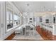 Open-concept dining area with a large table, waterfront views, and access to the kitchen at 8228 Bay Pointe Dr, Denver, NC 28037
