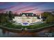 Expansive waterfront estate features a private pool, lush landscaping, and stunning architectural details at sunset at 8228 Bay Pointe Dr, Denver, NC 28037