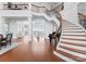 Elegant foyer featuring a grand staircase, hardwood floors, and stunning lake views through expansive windows at 8228 Bay Pointe Dr, Denver, NC 28037