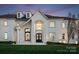 Grand entrance showcasing ornate wrought iron doors, stone detailing, dormer windows, and manicured landscaping at 8228 Bay Pointe Dr, Denver, NC 28037