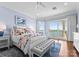 Bright bedroom boasts hardwood floors, water views, and a cozy sitting area with a tufted bench at 8228 Bay Pointe Dr, Denver, NC 28037