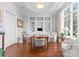 Cozy office space featuring built-in bookshelves, hardwood floors, natural light, and comfortable seating area at 8228 Bay Pointe Dr, Denver, NC 28037