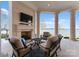 Covered outdoor seating area with a fireplace, plush chairs, and incredible water views at 8228 Bay Pointe Dr, Denver, NC 28037