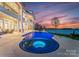The luxury pool and spa boasts integrated lighting, enhancing the backyard ambiance with a stunning view of the lake at 8228 Bay Pointe Dr, Denver, NC 28037