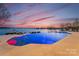 An inground pool with water features and a serene lake backdrop creates a luxurious outdoor retreat at 8228 Bay Pointe Dr, Denver, NC 28037