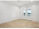 Sunlit bedroom with neutral walls and light wood floors, featuring double doors leading to water view at 8813 Graham Rd, Denver, NC 28037