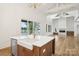 Bright and airy kitchen with island and view to the outdoor fireplace and lake at 8813 Graham Rd, Denver, NC 28037