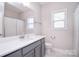 Bright bathroom featuring a grey vanity, white countertop, toilet, and a shower/tub combination at 9007 Raven Top Dr, Mint Hill, NC 28227