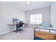 Bright bedroom with ample natural light, a bed with blue accents, and a spacious workspace at 9007 Raven Top Dr, Mint Hill, NC 28227