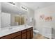 Bathroom showcasing double sinks with wood cabinets, a large mirror, and a glass-enclosed shower at 9017 Lanark Ln, Fort Mill, SC 29707
