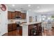 Open kitchen with granite countertop island and wooden cabinets leading to dining area at 9017 Lanark Ln, Fort Mill, SC 29707
