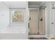 Bright bathroom features a walk-in shower, and a large soaking tub near a window for natural light at 9113 Cinder Ln, Huntersville, NC 28078