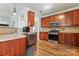 Beautiful kitchen featuring stainless steel appliances, warm wood cabinetry, and hardwood flooring at 9113 Cinder Ln, Huntersville, NC 28078