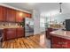 Spacious kitchen featuring stainless steel appliances, warm wood cabinets, and hardwood flooring at 9113 Cinder Ln, Huntersville, NC 28078