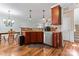 Stylish kitchen featuring stainless steel appliances, warm wood cabinetry, and hardwood flooring at 9113 Cinder Ln, Huntersville, NC 28078