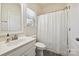 Bright bathroom featuring a vanity with sink, toilet, and a shower tub with white curtain at 9937 Travertine Trl, Davidson, NC 28036