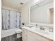 Bright bathroom featuring a shower-tub combo, marble shower curtain and a white vanity with a large mirror at 9937 Travertine Trl, Davidson, NC 28036