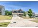 Elegant two-story home with brick facade, shutters, two-car garage, and a spacious driveway at 9937 Travertine Trl, Davidson, NC 28036