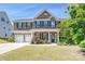 Beautiful brick home with three-car garage and well-manicured lawn on a sunny day at 9937 Travertine Trl, Davidson, NC 28036