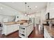 Kitchen offers white cabinets, granite countertops, stainless steel appliances, and a central island for meal preparation at 9937 Travertine Trl, Davidson, NC 28036