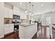 Kitchen showcasing white cabinets, granite countertops, stainless steel appliances, and an island with pendant lights at 9937 Travertine Trl, Davidson, NC 28036