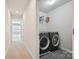 Hallway view of laundry room featuring a side-by-side washer and dryer and shelving at 9937 Travertine Trl, Davidson, NC 28036