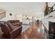 Spacious living room with hardwood floors, fireplace, and access to the kitchen and dining area, perfect for gatherings at 9937 Travertine Trl, Davidson, NC 28036