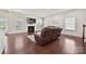 Living room with hardwood floors, fireplace, and large windows for natural light, creating a cozy and inviting atmosphere at 9937 Travertine Trl, Davidson, NC 28036