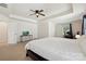 Large main bedroom with tray ceiling, ceiling fan, a television, and home office desk at 9937 Travertine Trl, Davidson, NC 28036