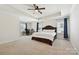 Spacious main bedroom featuring a tray ceiling, ceiling fan, and home office area at 9937 Travertine Trl, Davidson, NC 28036