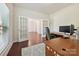 Well-lit home office with hardwood floors and view of living room through French doors at 9937 Travertine Trl, Davidson, NC 28036