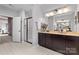 Spacious bathroom featuring a glass enclosed shower, dual sink vanity, tile flooring, and decorative accents at 11523 Warfield Ave, Huntersville, NC 28078