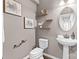 A half bathroom with a pedestal sink, a decorative mirror, and stylish wall decor creating an inviting space at 11523 Warfield Ave, Huntersville, NC 28078