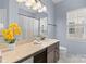 Powder blue bathroom with a large countertop, decorative lighting, and window at 11523 Warfield Ave, Huntersville, NC 28078