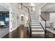 Grand foyer with dark wood floors, a staircase with white risers, and an adjacent office with glass doors at 11523 Warfield Ave, Huntersville, NC 28078