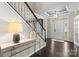 Elegant foyer with dark wood floors, a staircase with white spindles, and a transom window above the front door at 11523 Warfield Ave, Huntersville, NC 28078