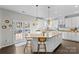 Bright kitchen featuring white cabinets, granite countertops, a kitchen island with seating, and backyard patio access at 11523 Warfield Ave, Huntersville, NC 28078