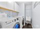 Well-organized laundry room equipped with a washer, dryer, upper cabinets, and a utility sink for added convenience at 11523 Warfield Ave, Huntersville, NC 28078