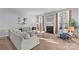 Sunlit living room with neutral tones, a cozy fireplace, large windows, and comfortable seating arrangements at 11523 Warfield Ave, Huntersville, NC 28078